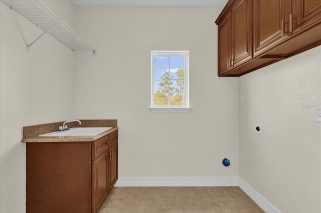 laundry room featuring electric dryer hookup, light tile patterned flooring, cabinets, and sink