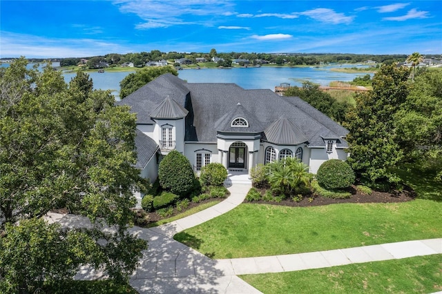 view of front facade featuring french doors, a water view, and a front yard