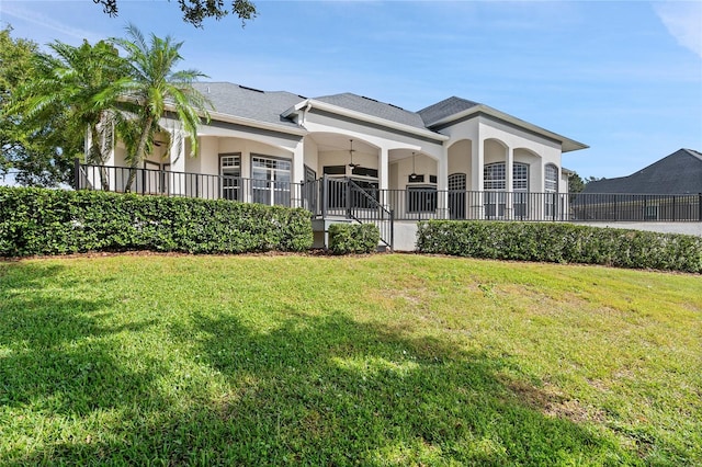 back of house with a lawn and ceiling fan