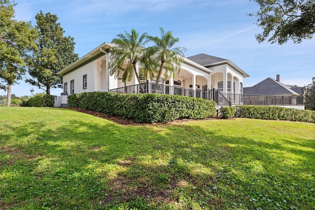 view of home's exterior with covered porch and a yard