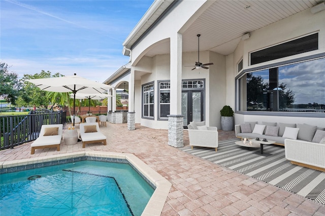 view of pool with an outdoor hangout area, a patio, and ceiling fan