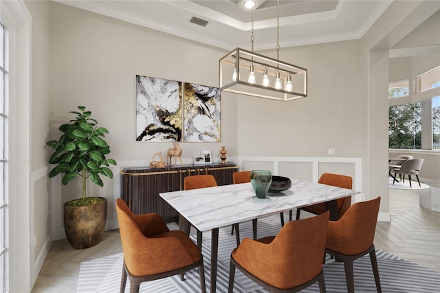 dining area with parquet flooring, a chandelier, a raised ceiling, and ornamental molding