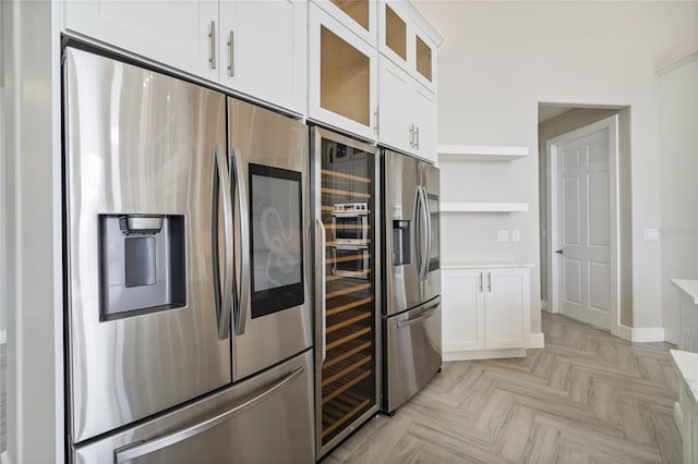 kitchen with white cabinetry, light parquet flooring, and stainless steel refrigerator with ice dispenser