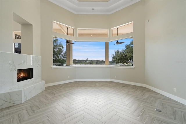 unfurnished living room featuring a premium fireplace, light parquet floors, and a healthy amount of sunlight