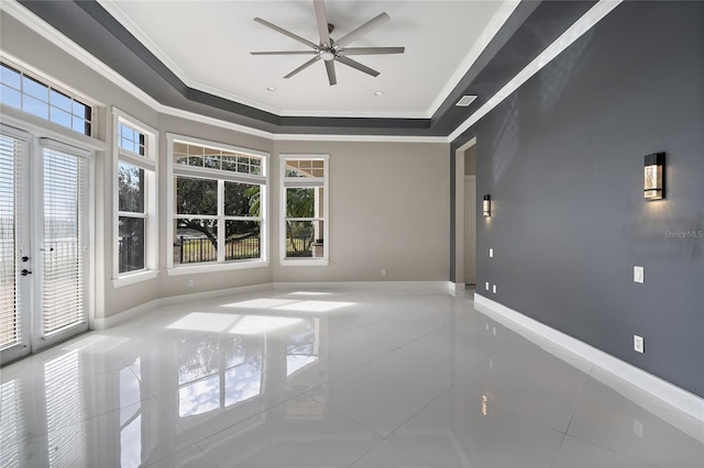 spare room featuring a tray ceiling, tile patterned floors, ceiling fan, and ornamental molding