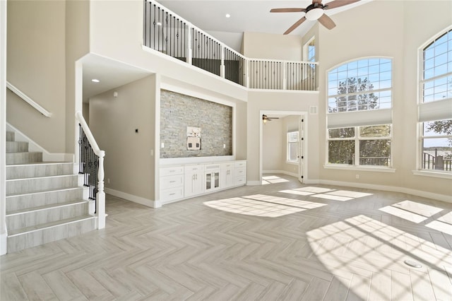 unfurnished living room with a high ceiling and light parquet flooring