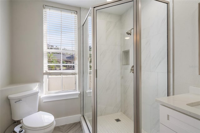 bathroom featuring walk in shower, vanity, toilet, and a wealth of natural light