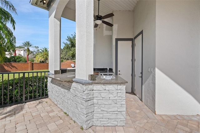 view of patio / terrace with area for grilling, ceiling fan, and an outdoor wet bar