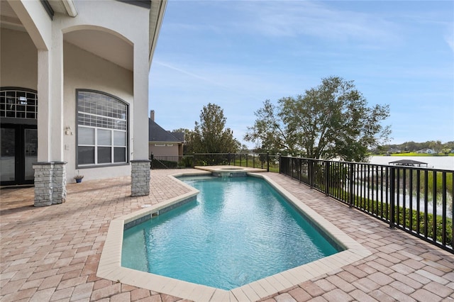 view of swimming pool featuring a patio area, an in ground hot tub, and a water view