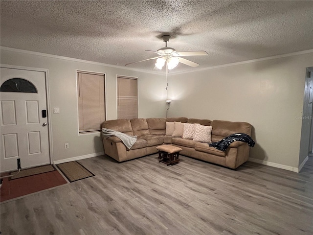 living room with hardwood / wood-style flooring, ceiling fan, crown molding, and a textured ceiling