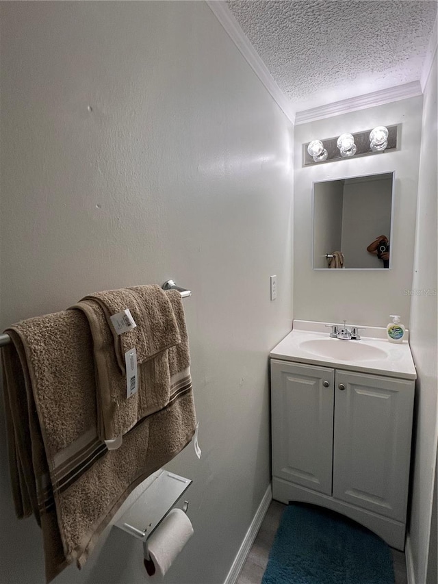 bathroom with vanity, ornamental molding, and a textured ceiling