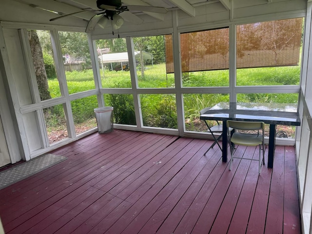 unfurnished sunroom featuring ceiling fan