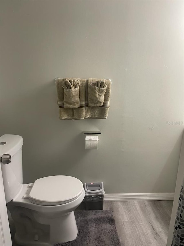 bathroom with hardwood / wood-style flooring and toilet