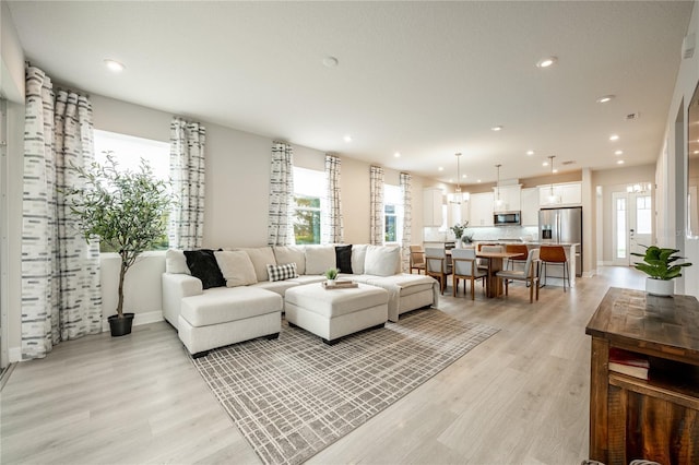 living room featuring plenty of natural light and light hardwood / wood-style flooring