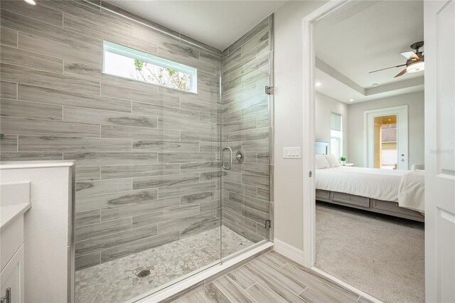 bathroom with ceiling fan, a shower with door, and vanity