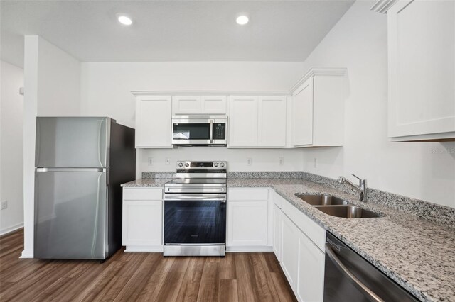 kitchen featuring sink, white cabinetry, stainless steel appliances, dark hardwood / wood-style flooring, and light stone countertops