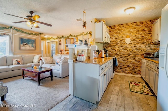 kitchen featuring white cabinets, light hardwood / wood-style floors, and a textured ceiling