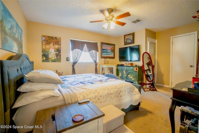 bedroom featuring a textured ceiling, carpet floors, and ceiling fan