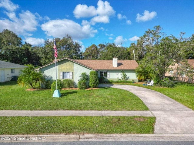 view of front of house with driveway, a chimney, a front yard, and stucco siding