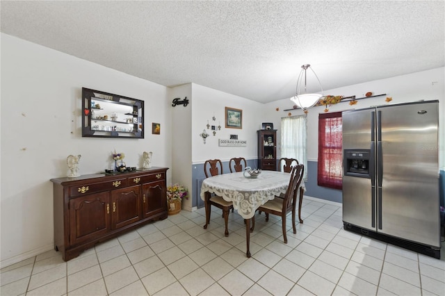 dining area featuring light tile patterned flooring and a textured ceiling