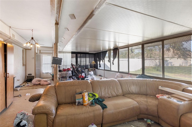 living room featuring carpet, beam ceiling, and a chandelier