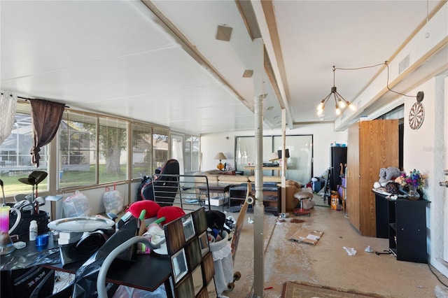 misc room featuring concrete floors and an inviting chandelier