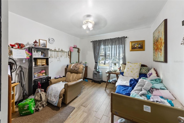 living area featuring light hardwood / wood-style floors and ceiling fan