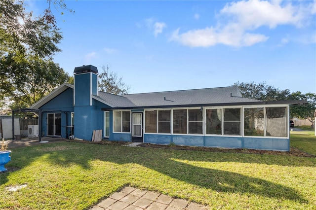 back of property with a lawn and a sunroom