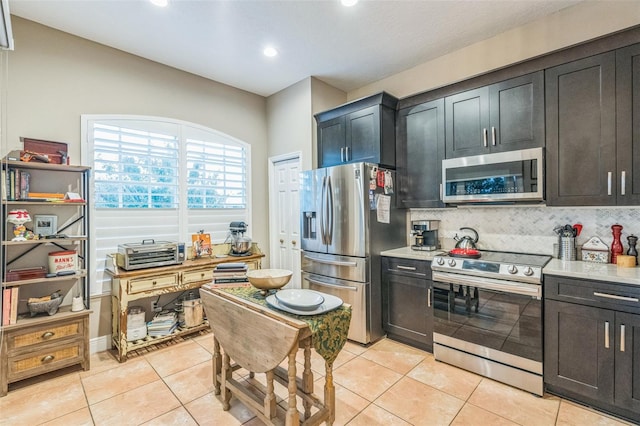 kitchen with decorative backsplash, light tile patterned flooring, and appliances with stainless steel finishes