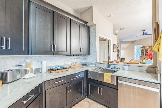 kitchen with sink, ceiling fan, light tile patterned floors, a textured ceiling, and light stone counters