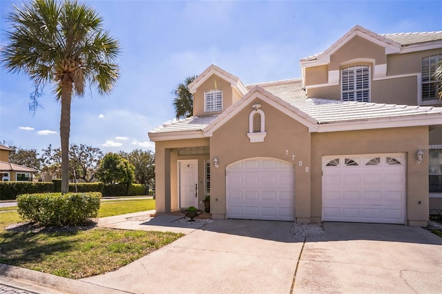 view of front of home featuring stucco siding, concrete driveway, and a tile roof