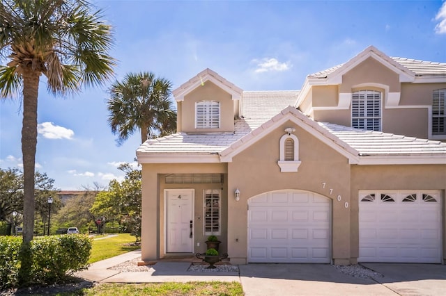 view of front facade featuring stucco siding, driveway, and a tile roof