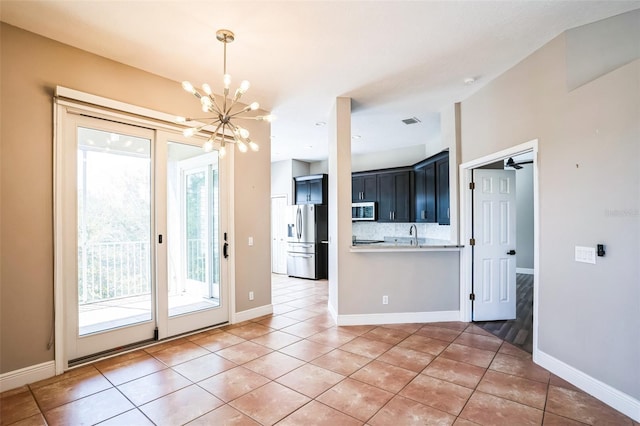 interior space with an inviting chandelier, light tile patterned flooring, baseboards, and visible vents