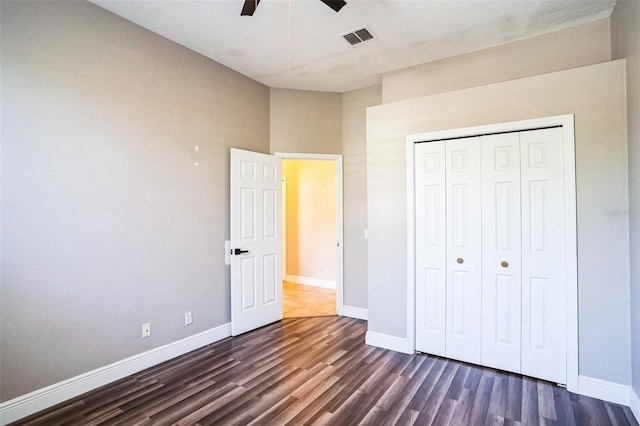 unfurnished bedroom with dark wood-style floors, visible vents, and baseboards