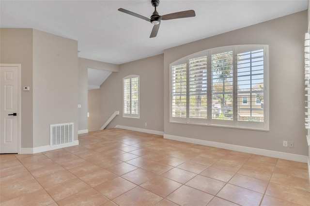 spare room featuring light tile patterned floors, visible vents, baseboards, and ceiling fan