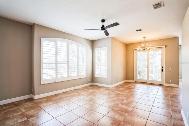 unfurnished room with light tile patterned floors, visible vents, baseboards, a textured ceiling, and ceiling fan with notable chandelier