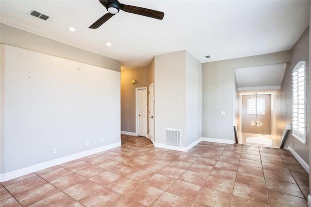 empty room with light tile patterned floors, baseboards, visible vents, and ceiling fan