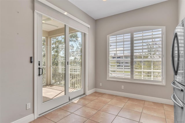 entryway with light tile patterned floors and baseboards