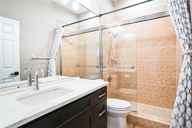 bathroom featuring vanity, toilet, and a tile shower