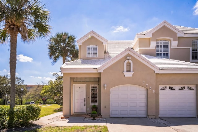 7700 Carriage Homes Dr Unit 4, Orlando, FL 32819 - view of front of home with a tile roof, stucco siding, and concrete driveway