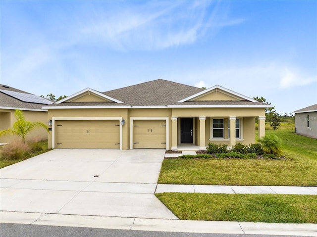 view of front of property featuring a porch, a garage, and a front yard