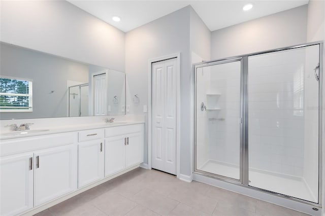 bathroom featuring tile patterned floors, vanity, and a shower with shower door