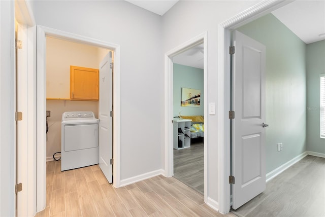 hall featuring light hardwood / wood-style flooring and washer / dryer