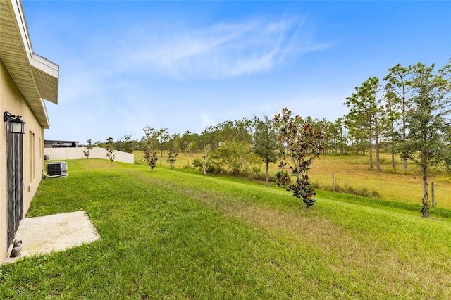 view of yard featuring central AC and a rural view