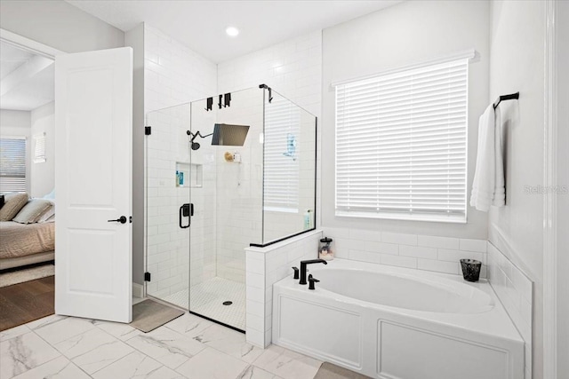 bathroom featuring shower with separate bathtub