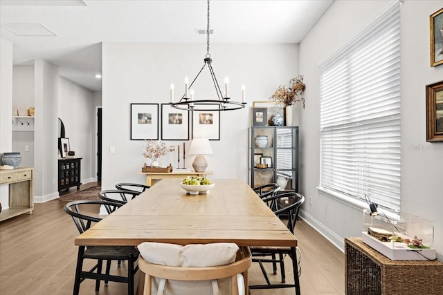 dining space featuring a chandelier, a healthy amount of sunlight, and light hardwood / wood-style floors