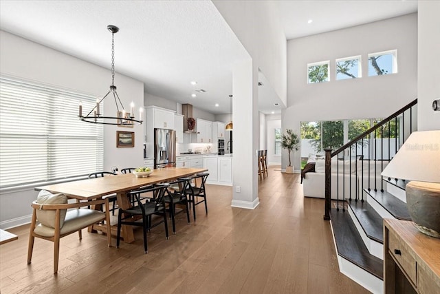 dining area featuring a chandelier, a high ceiling, and dark wood-type flooring