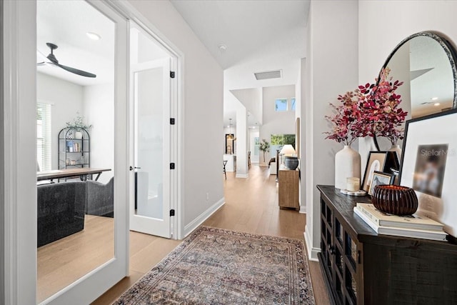 hallway featuring light wood-type flooring and french doors