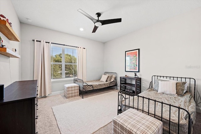 carpeted bedroom with ceiling fan and a textured ceiling