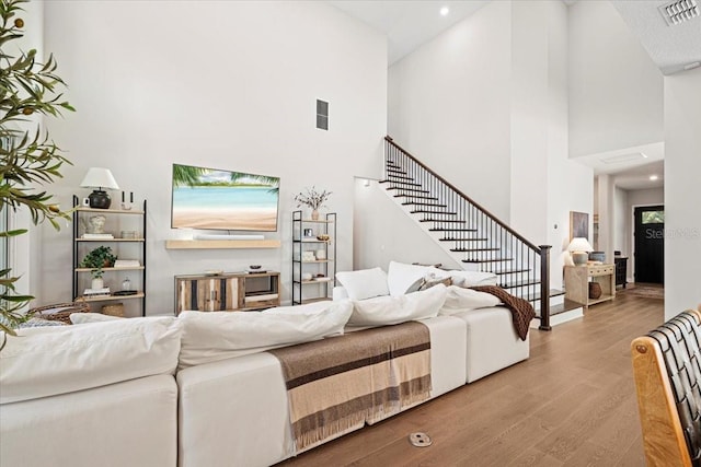 living room featuring hardwood / wood-style floors and high vaulted ceiling